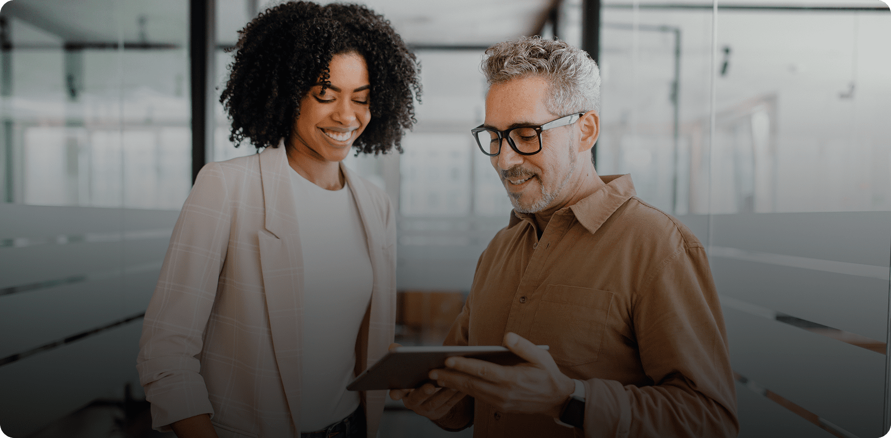Two colleagues discussing over a tablet.